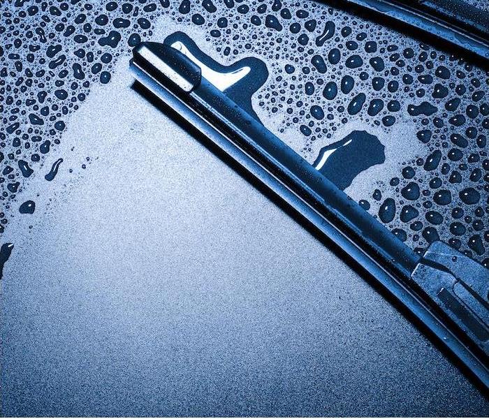 a close-up image of a wiper blade wiping away condensation on a car windshield