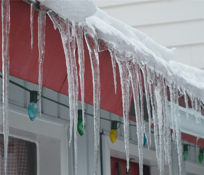 Icicles hanging from a home with Christmas lights 
