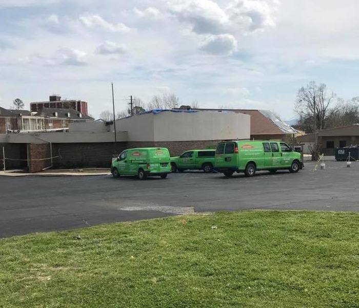 3 green SERVPRO vehicles parked outside a funeral home.