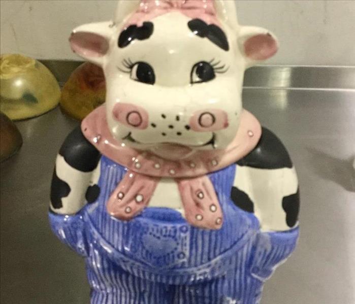 A cow cookie jar cleaned after a fire damage.