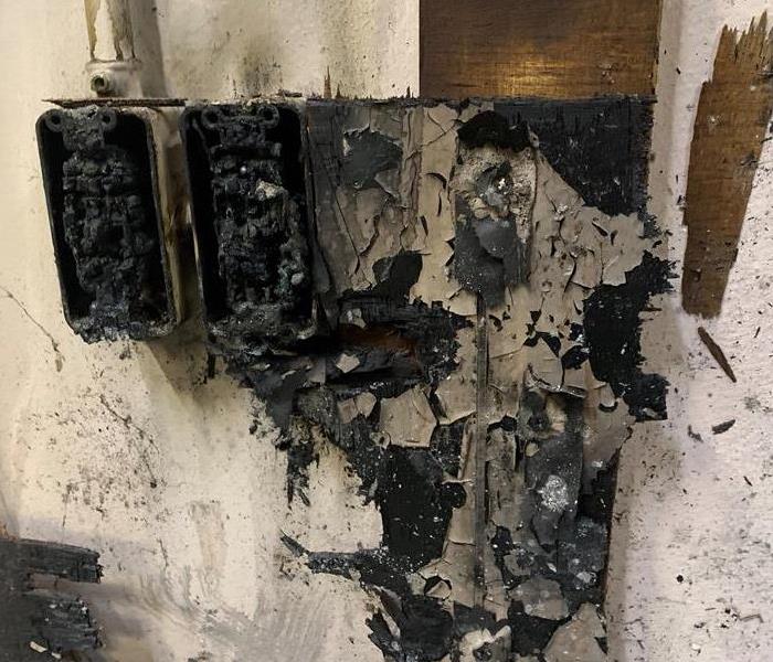 A badly burned electrical outlet that sparked a fire.